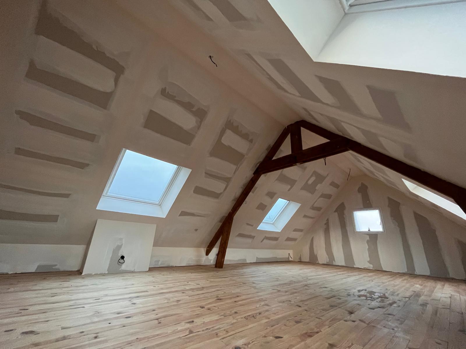 Artisan installant une menuiserie sur un chantier de rénovation.